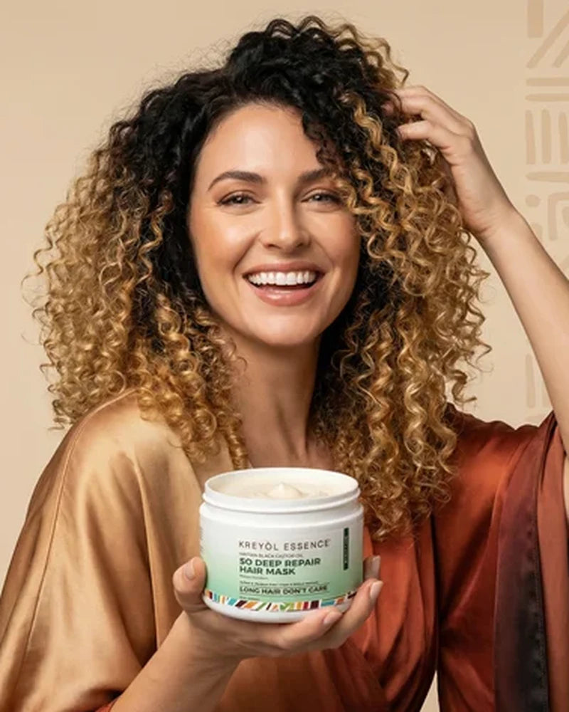 Woman with curly hair holding So Deep Repair hair mask