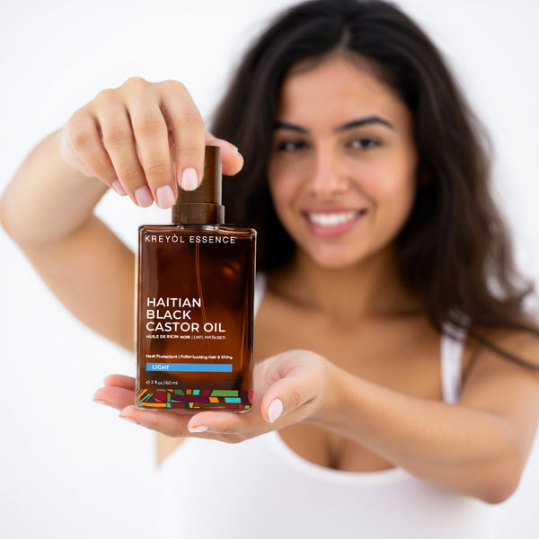 Kreyòl Essence Haitian Black Castor Oil Light for hair and skin, 2oz bottle, suitable for daily use as a hair treatment and skin moisturizer.