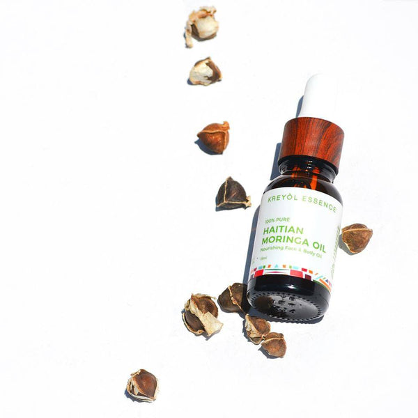 Haitian Moringa Oil by Kreyòl Essence, nourishing face and body skin care oil in a clear bottle with pump dispenser.