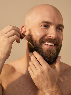 Kreyòl Essence Haitian Castor Oil Treatment for eyebrows, beard, and lashes on a bald man with white background.