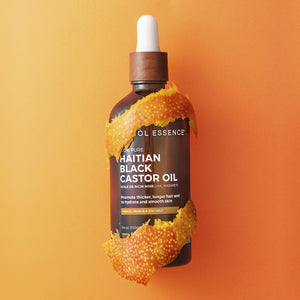 Haitian Black Castor Oil by Kreyòl Essence with mango and papaya scent, 3.4oz bottle, showing the oil and fresh mango peel.