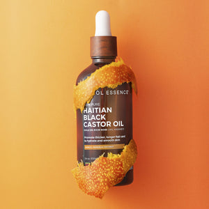Haitian Black Castor Oil by Kreyòl Essence with mango, papaya, and coconut extracts in a clear bottle showing the product label.