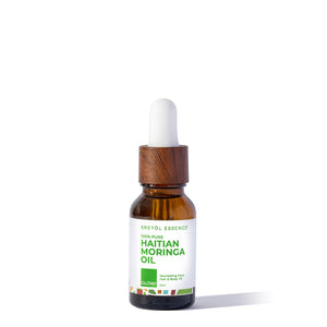 Haitian Moringa Oil by Kreyòl Essence in a 15ml bottle, nourishing face and body skin care oil with fresh Moringa leaves.