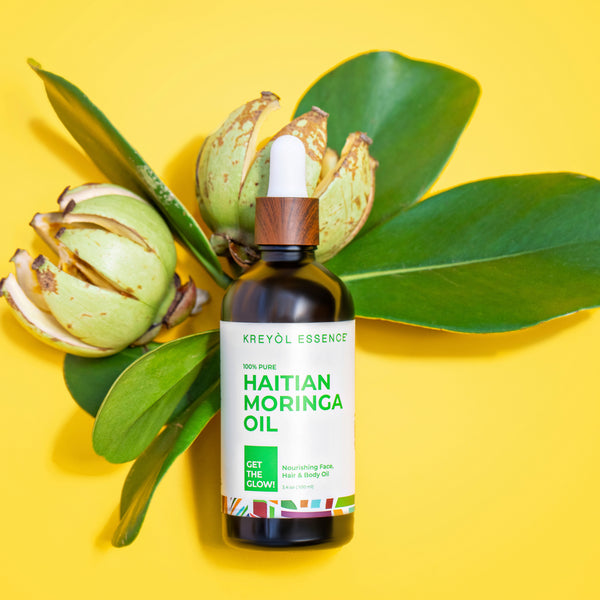 Kreyòl Essence Haitian Moringa Oil for face and body, 3.4oz, in a clear glass bottle with a black pump dispenser.
