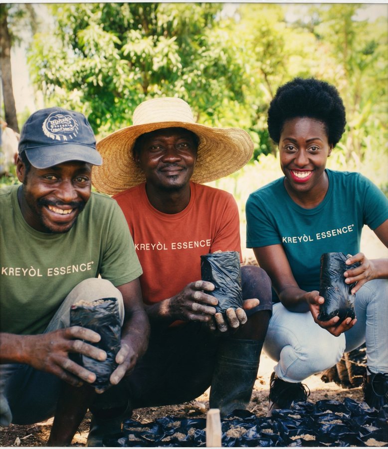 Yve-Car with farmers in Haiti holding castor seedlings