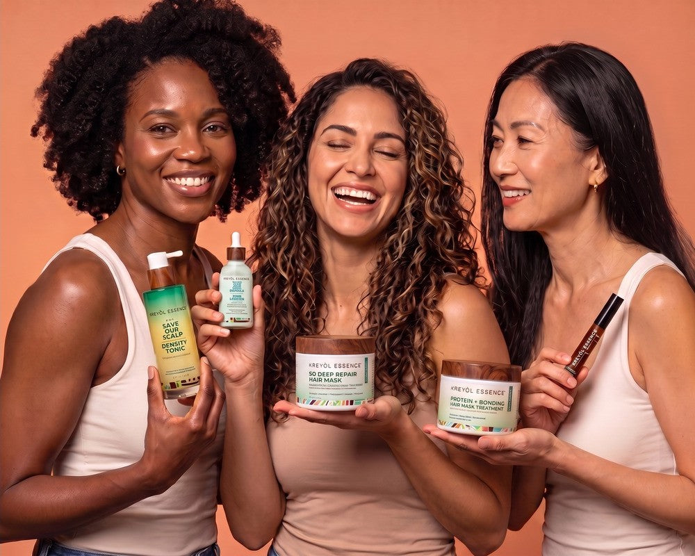 Three women with different hair types laughing and holding Kreyòl Essence GLP-1 Hair Plan products