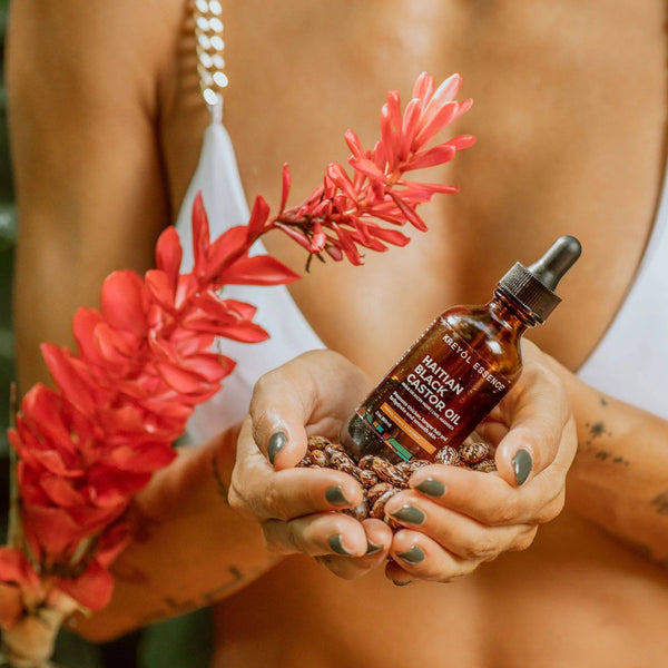 Kreyòl Essence Haitian Black Castor Oil in 2oz bottle with mango, papaya, and coconut, natural hair and skin care product