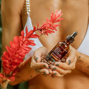 Haitian Black Castor Oil by Kreyòl Essence with mango, papaya, and coconut, shown in a clear bottle with natural ingredients.