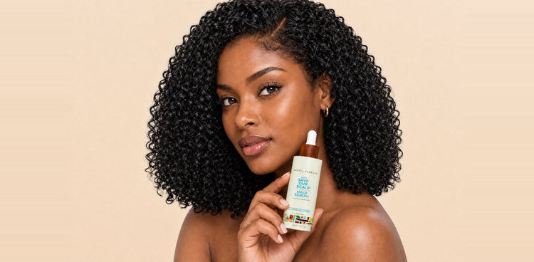 Woman with curly hair holding S.O.S. Serum