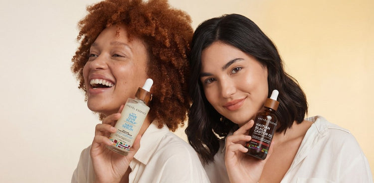 Two women holding Kreyòl Essence S.O.S Serum and Haitian Black Castor Oil
