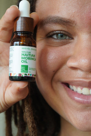 Kreyòl Essence Haitian Moringa Oil bottle for face and body, featuring natural skin care nourishing oil with a dropper applicator.