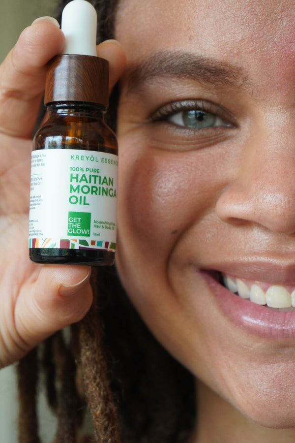 Kreyòl Essence Haitian Moringa Oil bottle for face and body, featuring natural skin care nourishing oil with a dropper applicator.