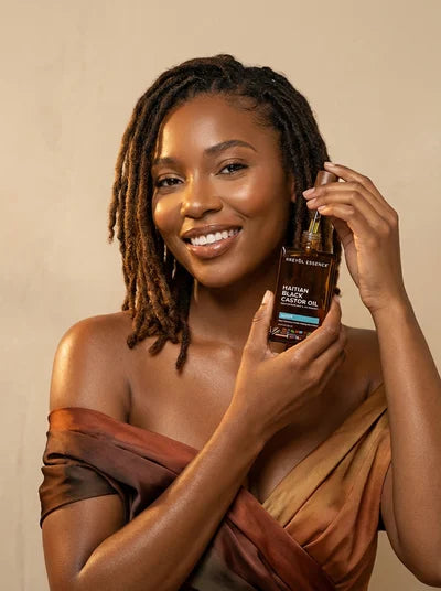 Woman with locs holding Haitian Black Castor Oil