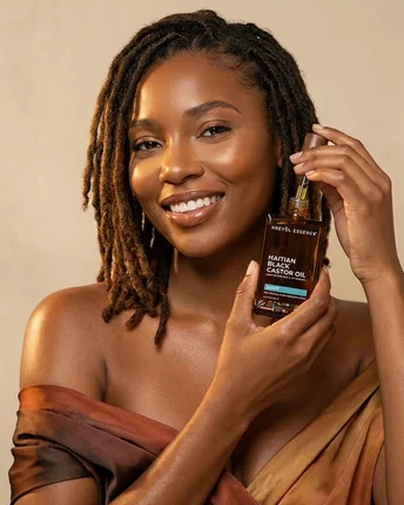 Woman with locs holding Haitian Black Castor Oil