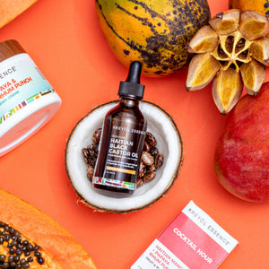 Stylized image of 2oz Haitian Black Castor Oil by Kreyòl Essence with Mango, Papaya, and Coconut scent notes.
