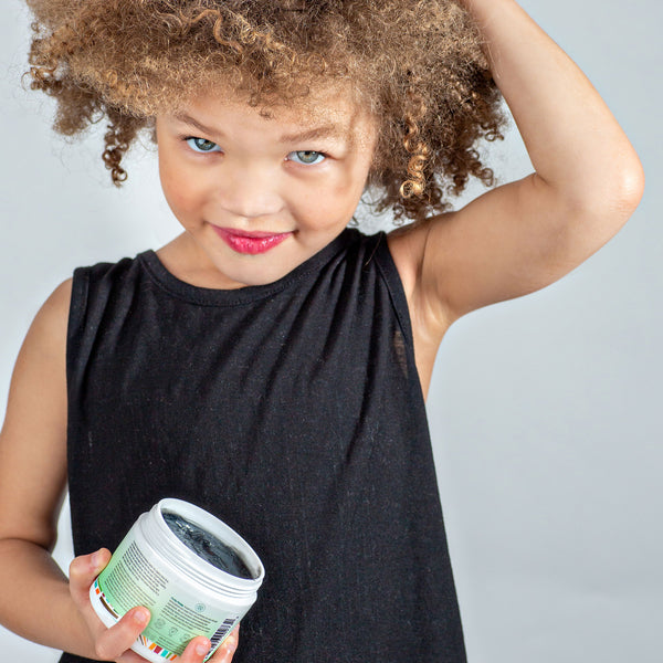 Kreyòl Essence Pomad Kreyòl Natural Scalp Balm for hair growth, 4oz, featuring a model applying the nourishing treatment to scalp.